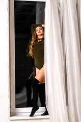 Obraz premium Sexy young woman in black sensual lingerie. Girl posing on brick wall in studio.