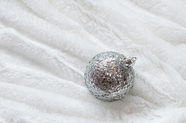 Silver christmas ball on white fur