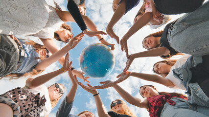 Earth conservation concept. 11 girls surround the rotating earth globe with their palms hands.