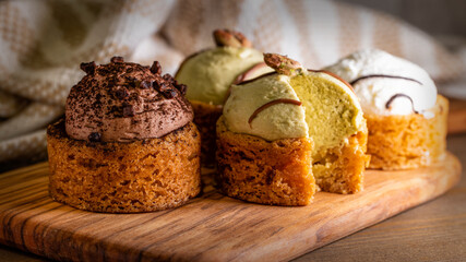 kleine Törtchen auf einem Holzbrett serviert