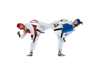 Plakat Portrait of two young women, taekwondo athletes practicing, fighting isolated over white background. Concept of sport, skills