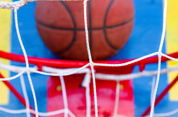Basketball ball near the backboard over the ring, close-up.