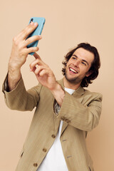 Cheerful man in a suit posing emotions looking at the phone isolated background