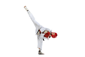 Young girl, taekwondo practitioner strikes forcibly with the foot isolated over white background....