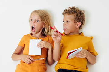 Boy and girl lie on the floor with notepads and pencils childhood lifestyle unaltered