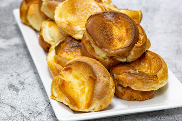 Individual Yorkshire puddings on a white rectangular plate.  Traditional British food concept