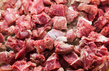 Diced pieces of raw beef roast, close-up.