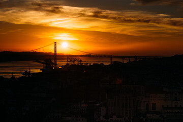Fototapeta na wymiar Sunset overlooking Lisbon's Baixa and 25 April Bridge on the Tagus River, Portugal