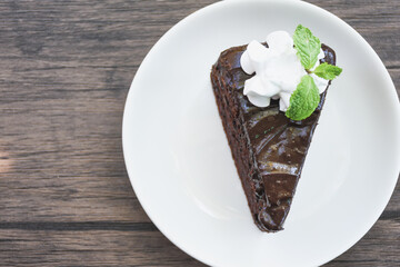 Closeup of chocolate cake in a plate on a wooden table