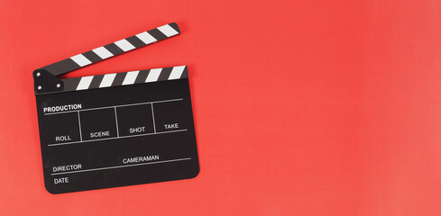 Fototapeta na wymiar Black clapper board or movie slate on red background.