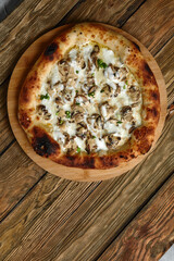 Delicious homemade pizza with mozzarella, mushrooms, beef and chicken. Wooden background, selective focus.