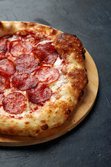 Tasty pepperoni pizza on black concrete background. Top view of hot pepperoni pizza. With copy space for text.
