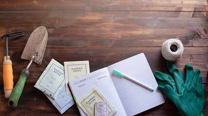 Top view of garden tools and seeds packets on wooden table. Image with copy space. Spring gardening concept