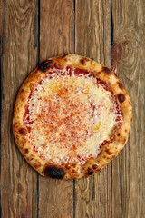 Pizza Margherita on wooden background, top view. Flyer and poster for Restaurants or pizzerias, template with delicious taste margarita pizza, mozzarella cheese