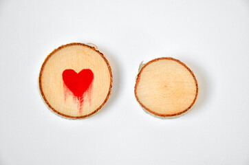 Pine tree slice with red blood heart symbol on white background. Valentines day wallpaper