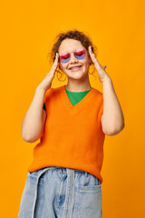 beautiful woman orange sweatshirts sunglasses multicolored glasses supply yellow background unaltered