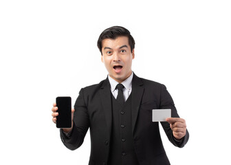 Handsome business man in black suit holding credit card and using smartphone for online shopping isolated on white background. Business, technology, ecommerce and online payment concept.