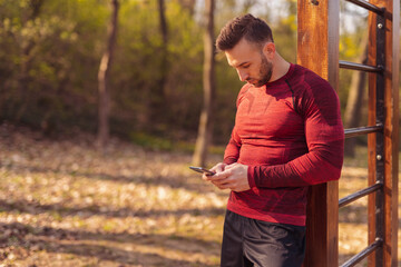 Man using smart phone while working out outdoors