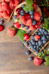 Various fresh berries on a wooden table.