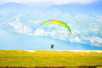 Gleitschirmfliegen am Gardasee mit Bergpanorama im Hintergrund See Paragleiter Italien Sport Berg /...