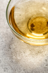 A glass with green herbal tea on grey background. Minimalism. Close up