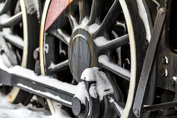 Locomotive wheels close-up with snow in winter