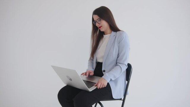 Young girl dreamily looks at the ceiling and sighs heavily, pressing the spacebar while waiting for the page to load on a laptop