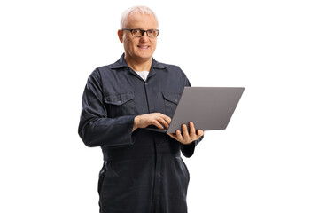Mature male worker in an overall uniform with a laptop computer