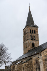 Fototapeta na wymiar Romanesque church tower in a village. Winter photography with snowy landscape.