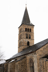 Fototapeta premium Romanesque church tower in a village. Winter photography with snowy landscape.
