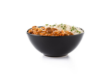 Indian butter chicken in black bowl isolated on white background