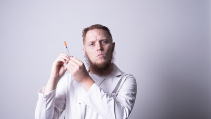 a young doctor in a mask holds an inzulin syringe