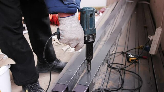 Rivet pistol in action, worker installing rivets