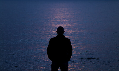 Silhouette of adult man looking at sea during sunset. Almeria, Spain