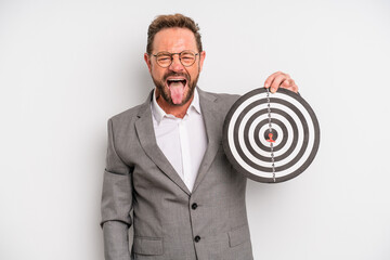 middle age man with cheerful and rebellious attitude, joking and sticking tongue out. target darts...