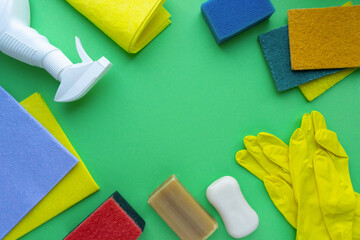 Frame of various cleaning products and items on green background