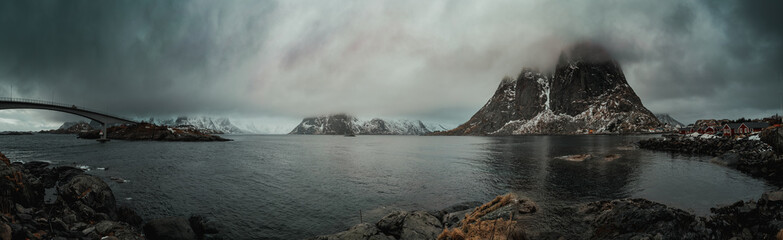 Norwegian fjords in spring and mountains at low clouds panorama