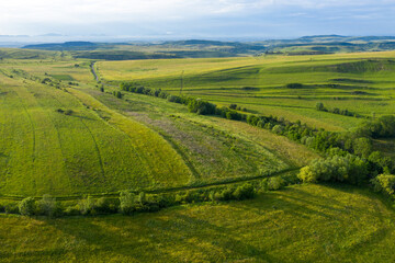 Fototapeta premium Aerial view of countryside vibrant green hills. Transylvania, Romania