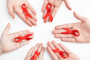 Health care and medicine concept. AIDS awareness. Many people hands are holding red awareness ribbons. International AIDS Day