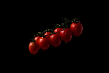freeze motion. Cherry tomatoes on black background with splashing water