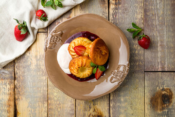 cheesecakes from cottage cheese on brown plate on wooden table top view