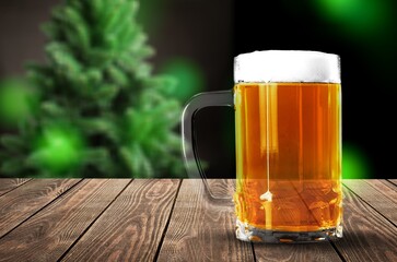 Beer in mug on wooden table with Christmas background
