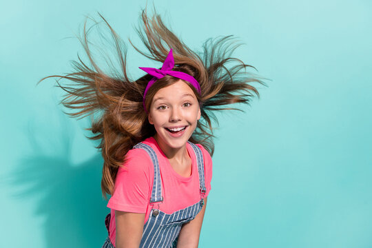 Photo of crazy preteen girl flying haircut enjoy season holiday wear striped outfit isolated on cyan color background