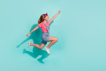 Full size profile portrait of carefree excited girl raise fist look empty space isolated on...