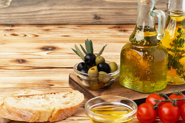 Olives and bottle of olive oil on wooden background