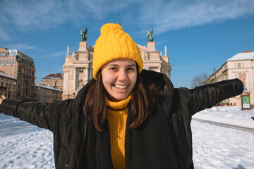 happy woman traveler in front of opera building in lviv city