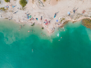 Fototapeta na wymiar aerial view of people swimming sunbathing resting at sandy beach