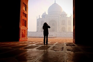Woman taking pictures of the Taj Mahal 