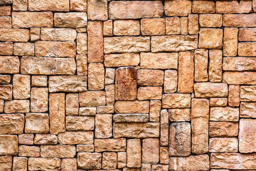 stone wall seamless texture close-up. Bright brown rock tile texture. Tile faceted stone wall background for design. Modern architecture, granite structure