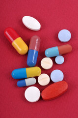 Assortiment de médicaments en gros plan sur fond rouge